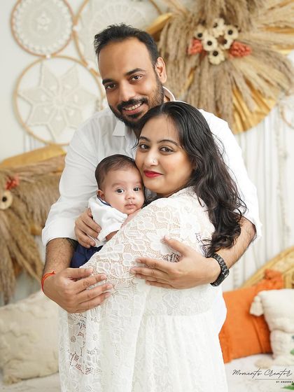 A beautiful family portrait taken during a three-month milestone session. The parents' embrace around their baby boy shows the warmth and love that fills their home.