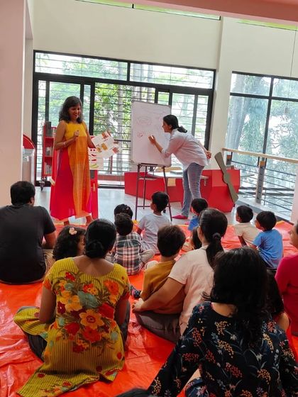 The audience of parents and children captivated by the storytelling and live drawing.