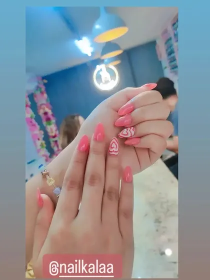 A cute and playful design with a solid coral base and accent nails featuring hand-painted white hearts.