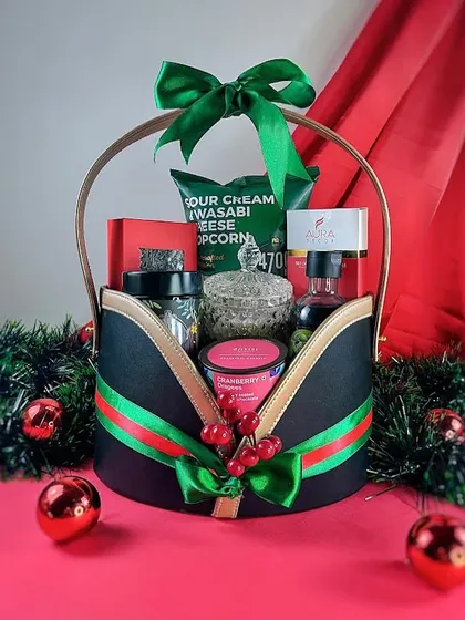 The 'Winter Wonderland' hamper is one of my most exquisite holiday options. It features a unique black and gold basket filled with gourmet popcorn, premium coffee, and other festive treats.
