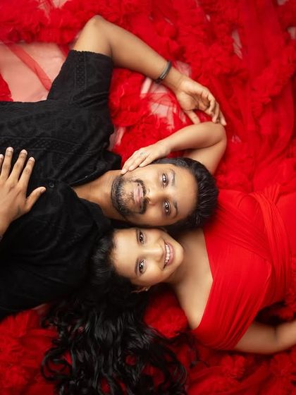 An aerial shot of a couple nestled in a sea of red tulle creates such a striking and intimate image. This creative studio setup focuses entirely on their connection and the love surrounding their little miracle.