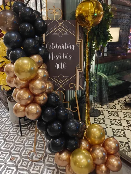We created a custom welcome sign for Nishita's 40th birthday, designed in a sophisticated Art Deco style. The black and gold balloon arrangement ties the whole look together.
