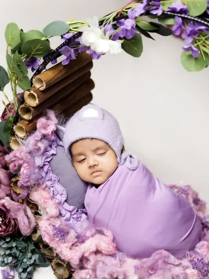 A full view of our floral hoop setup with a peacefully sleeping newborn. We use soft textures and coordinating colors to create a beautiful, artistic portrait.