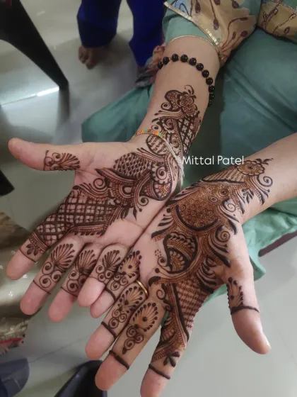 This is a classic example of a "siders" mehndi design, featuring a beautiful peacock motif. It provides good coverage and a traditional feel, perfect for guests who want a timeless henna pattern.