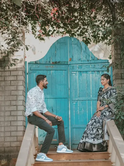 A candid moment between the couple against a rustic blue door. This shot combines traditional attire with a touch of vintage charm.