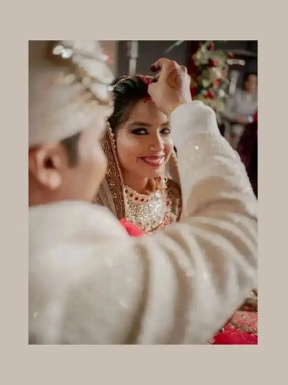The Sindoor moment, a close-up capturing the groom applying the vermilion and the bride's serene expression.
