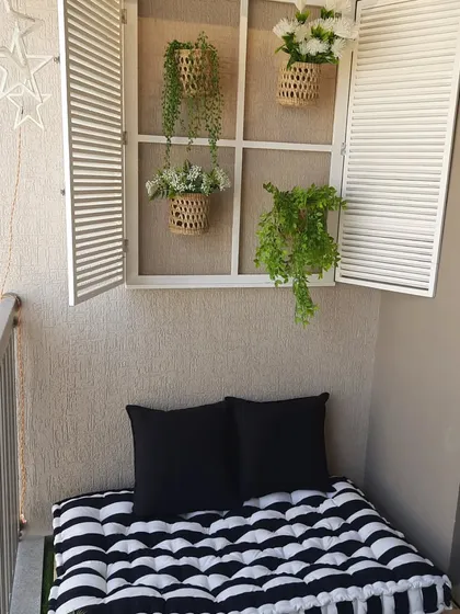 A cosy reading nook is a dream for so many. I created this peaceful corner using a low wooden pallet bench with a comfy striped mattress and a decorative French window to add a touch of architectural charm to a plain wall.