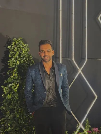 A smiling shot in my blue sequined blazer. I believe in looking good and feeling good to deliver the best performance for my clients.