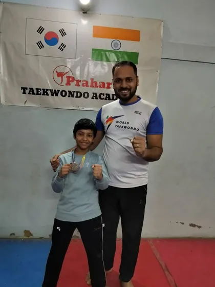 A young fighter proudly shows his two medals from the district tournament.