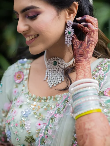 A detailed shot of the bride's Mehendi and her stunning diamond and emerald jewelry. We love capturing the combination of traditional art and modern elegance.