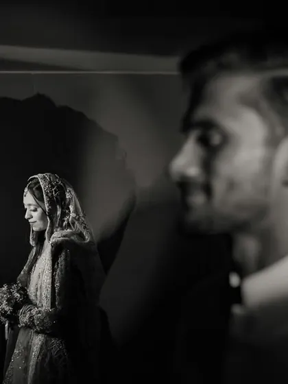 A creative portrait where love is painted with light and shadow. The groom's silhouette creates a powerful frame for his bride, showcasing an artistic and modern approach to wedding photography that tells a deeper story.