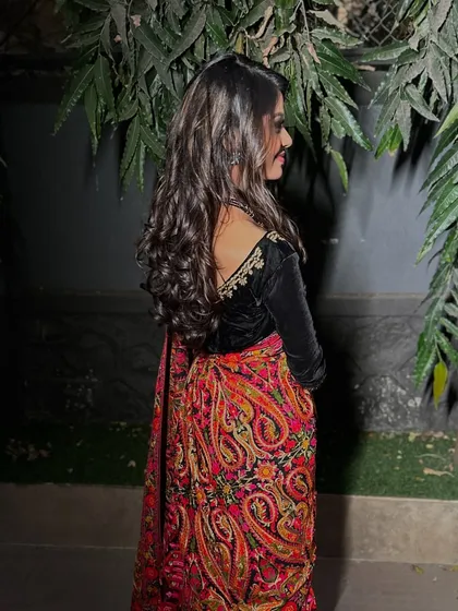A back view highlighting the velvet blouse and the soft curls in the hair.