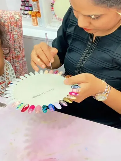 A student shows off her practice wheel, filled with a variety of colorful and creative nail art designs.