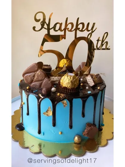 A chocolate overload cake for a 50th birthday. The blue cake provides a pop of color against the rich chocolate drip and toppings.