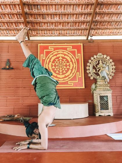 A student demonstrates incredible strength and balance in Pincha Mayurasana (Feathered Peacock Pose). Our shala, with its sacred geometry and inspiring art, provides the perfect container for such focused practice.