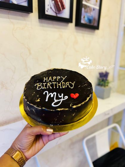 A simple and sweet chocolate birthday cake. The handwritten message and heart make it a personal and heartfelt treat.