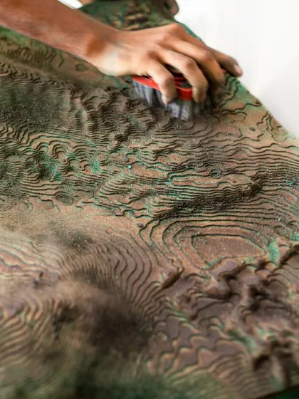 Craftsmanship is at the heart of our work. Here, an artisan meticulously refines the surface of the sculptural mountain wall for the Soaltee lobby. This hands-on process ensures every detail aligns with our vision of bringing the texture of the landscape indoors.