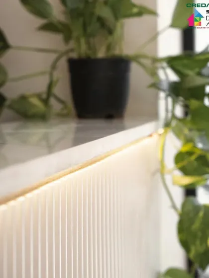 We pay close attention to lighting details. Here, subtle strip lighting under a shelf highlights the texture of the fluted wall and adds a warm glow.
