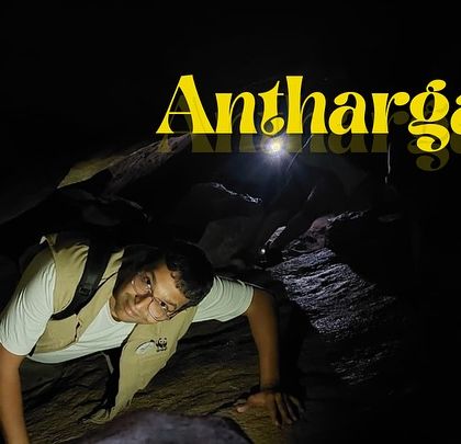 A trekker navigating the narrow passages of the Anthargange caves. It's a thrilling experience that tests your flexibility and courage.