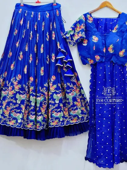 Another peacock-print lehenga in a rich blue, showcasing the versatility of the design.