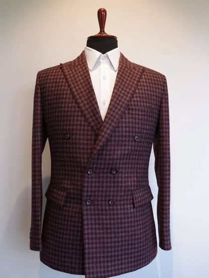 A full view of our double-breasted maroon check coat, a timeless piece that can be customized to your fit.