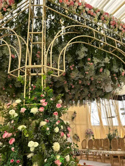 A closer look at the intricate construction of the floral canopy mandap. You can see the delicate balance of greenery, pink roses, and baby's breath, all woven into a golden frame to create a living work of art.