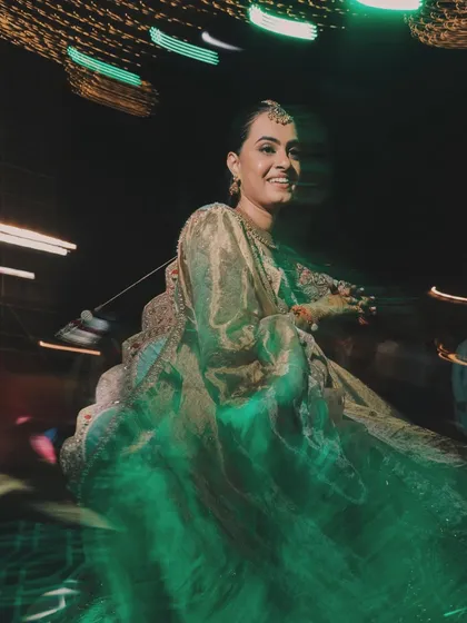 The bride twirling on the dance floor, her happiness illuminated by green stage lights. We use creative lighting techniques to create dynamic and colorful party shots.