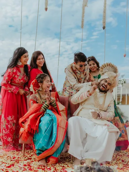 A candid shot of the couple sharing a laugh with their friends and family during the wedding ceremony.