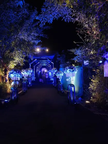 The pathway leading through the neon arches was lined with tall floral stands, bathed in blue light to continue the immersive, futuristic experience.