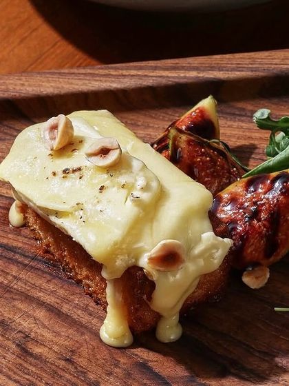 A close-up of the melted brie, figs, and hazelnuts on our popular toast, a perfect starter or light brunch plate.