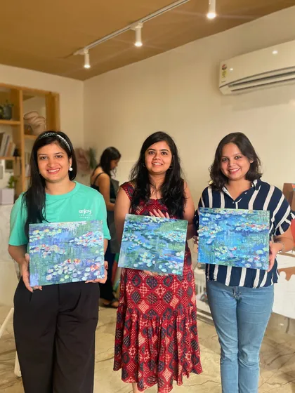 Three friends showing off their beautiful Monet-inspired water lily paintings. A perfect group activity for an afternoon of art.