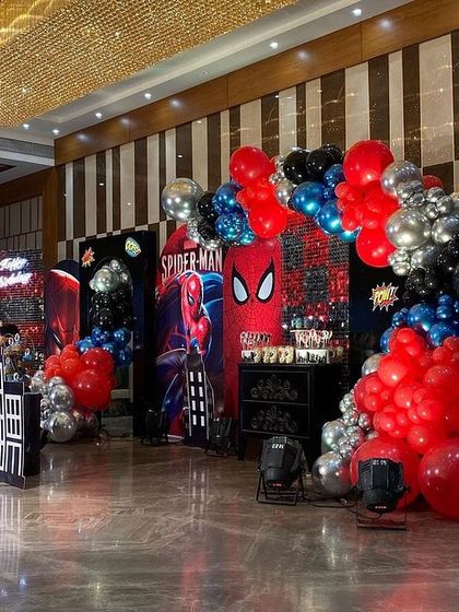 A side view of the Spider-Man party decor, showing the depth created by layering backdrops, props, and balloon garlands.