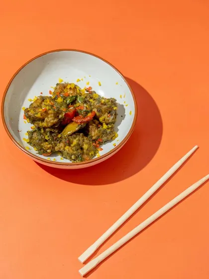 For this shot, we used a bold, solid orange background to make the product pop. This minimalist approach, combined with simple props like chopsticks, creates a modern and clean look.