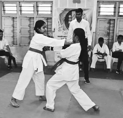 Two of our young karate students demonstrate their kumite (sparring) skills during a belt examination. These exams are important milestones, testing not just technique but also courage, control, and respect for one's opponent.