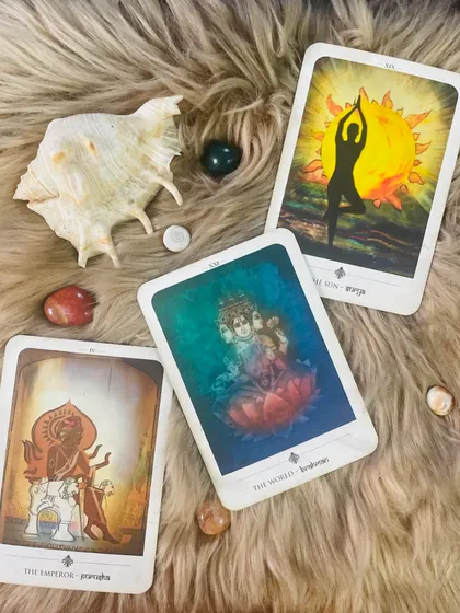 A beautiful spread of cards from a deck inspired by Indian mythology, laid out on a soft cloth with crystals and a shell. This setup shows how I create a sacred and peaceful environment for a reading, inviting calm and intuitive energy.