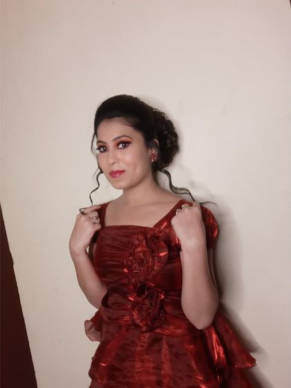 This client was styled for a party in a beautiful red gown. I created a glamorous makeup look with shimmery red and gold eyeshadow and a curly updo to match the romantic feel of the dress.