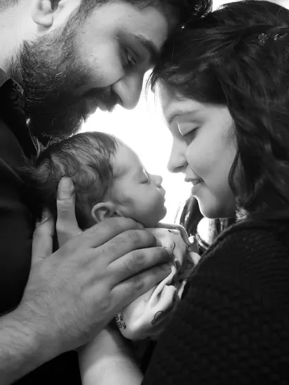 A beautiful black and white portrait of new parents adoring their sleeping baby. These first family photos are treasures that last a lifetime.