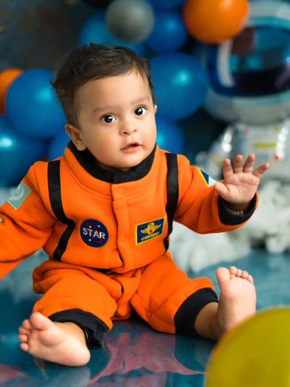A little astronaut exploring the galaxy. This space-themed shoot with planets and rockets is a fun adventure for a curious baby.