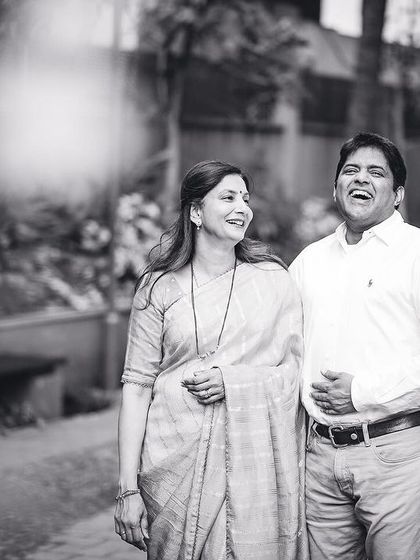 A black and white photo of a couple sharing a heartfelt laugh during their outdoor photoshoot.