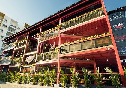 The exterior of Big Pitcher, Sarjapur, where we used landscaping to soften a large, industrial-style building. Rows of planters with tropical foliage create a green facade that welcomes guests.