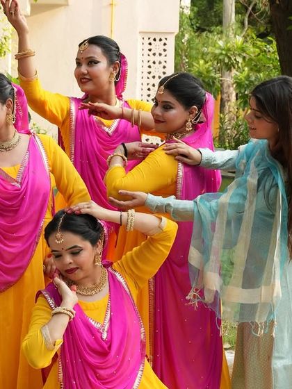 A candid moment while I adjust a student's pose during a group rehearsal. Choreographing for groups involves creating formations and ensuring each dancer's movements are synchronized and expressive.