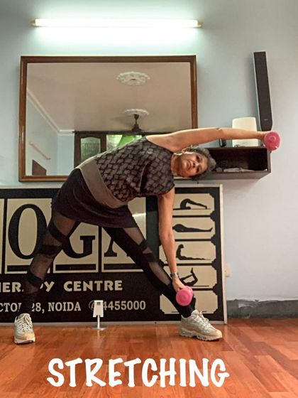 A standing side bend with light weights. I sometimes incorporate props to add a new dimension of strength and stretching to the practice.