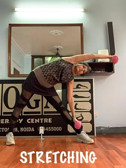 A standing side bend with light weights. I sometimes incorporate props to add a new dimension of strength and stretching to the practice.