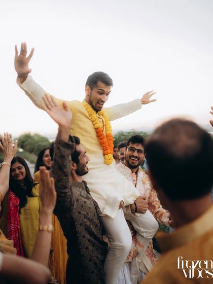 The groom being lifted on shoulders during the celebration. These moments of pure joy and camaraderie are what wedding celebrations are all about.