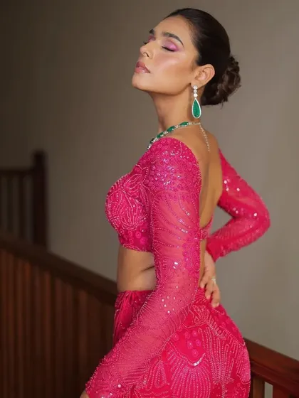 A vibrant pink embroidered lehenga by Mishru. The long sleeves and deep neckline create a chic and contemporary silhouette.