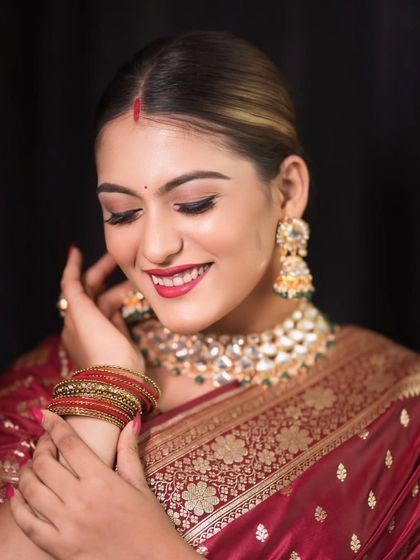 A candid, smiling portrait of the bride looking down, capturing a moment of genuine happiness and shyness.