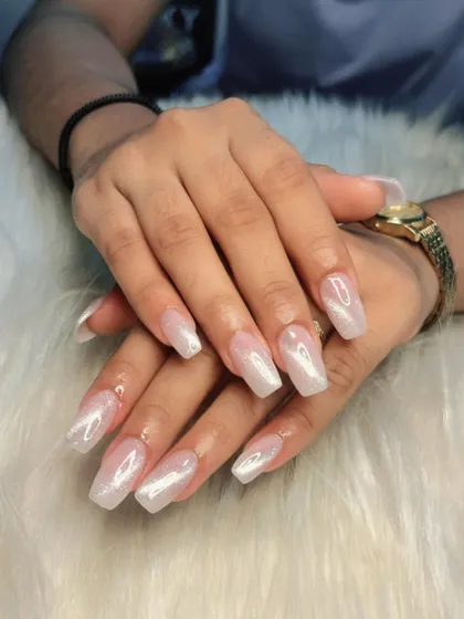 A beautiful set of long, coffin-shaped cat-eye nails. The pearly white shimmer gives them an elegant and almost magical appearance.