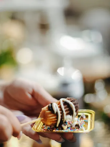 A guest enjoying a freshly prepared churro. Our live dessert counters are all about creating joyful and interactive food experiences.