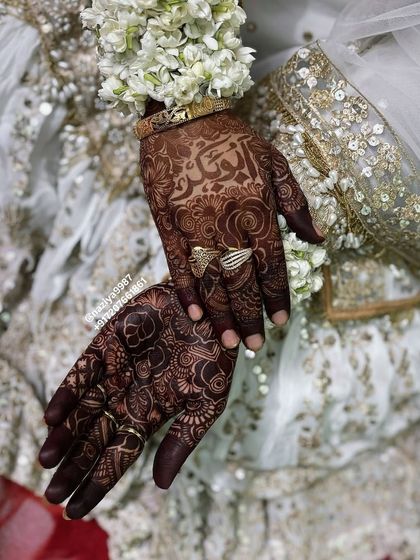 A close-up of the bride's hands, showing her personalized henna.