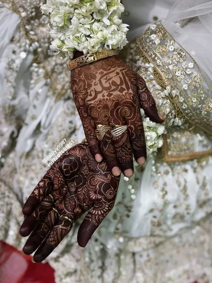 A close-up of the bride's hands, showing her personalized henna.